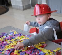 A little fireman helps himself to some candy. photo by Ari Esposito